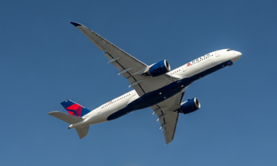 Delta Airlines Airbus A350 aircraft making a turn in a clear blue sky, with 'LAX' subtly glowing on a map in the background.
